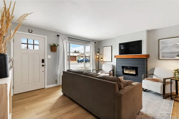 a living room with furniture a flat screen tv and a fireplace