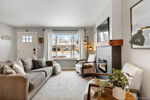 a living room with furniture fireplace and a large window