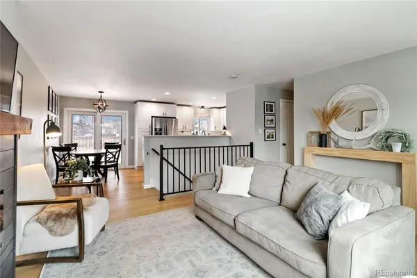 a living room with furniture and a dining table with wooden floor