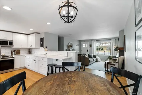 a large kitchen with a table chairs refrigerator and cabinets