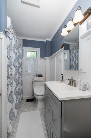 a bathroom with a sink a toilet and mirror