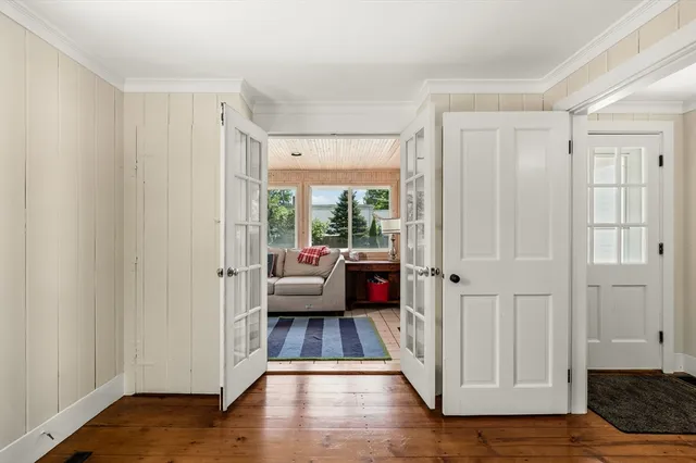 a view of a bedroom with wooden floor and windows