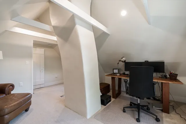 a view of a workspace with furniture and a window