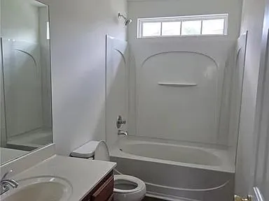 a bathroom with a granite countertop toilet sink and shower