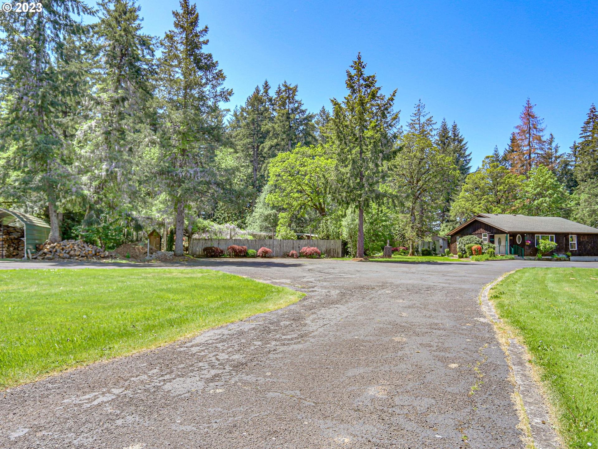 24347 Southeast Filbert Road Eagle Creek, OR 97022 - Photo 6 of 48 a view of a house with a big yard and palm trees