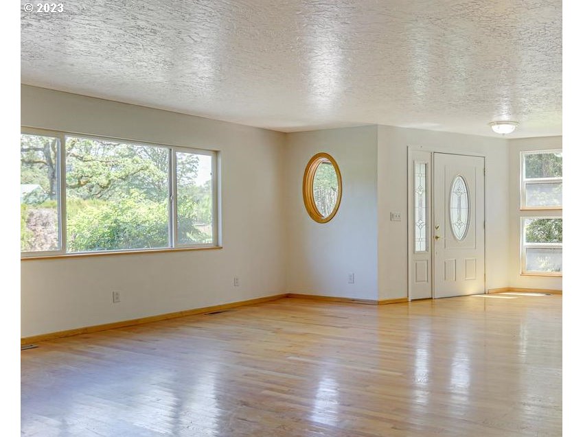 24347 Southeast Filbert Road Eagle Creek, OR 97022 - Photo 7 of 48 an empty room with wooden floor and windows