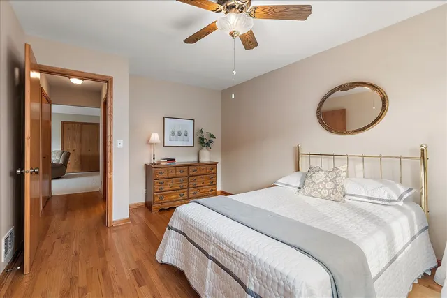 a bedroom with bed and wooden floor