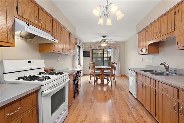 a kitchen with stainless steel appliances a stove a sink dishwasher and cabinets with wooden floor