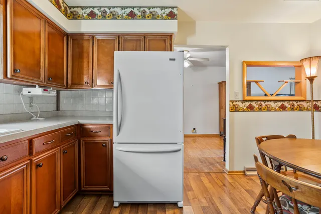 a kitchen with a refrigerator a sink and wooden cabinets