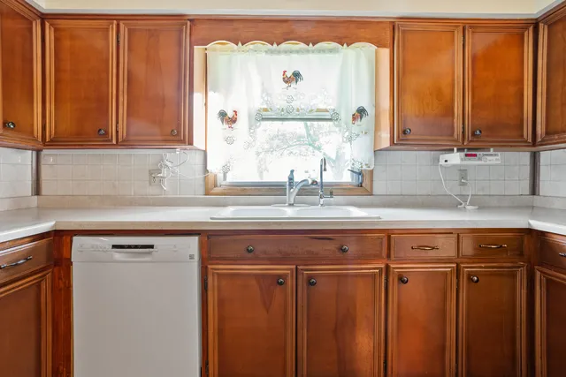 a view of a kitchen with a sink window and cabinets
