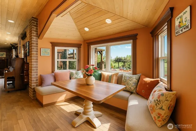 a dining hall with stainless steel appliances kitchen island granite countertop a table chairs and a refrigerator