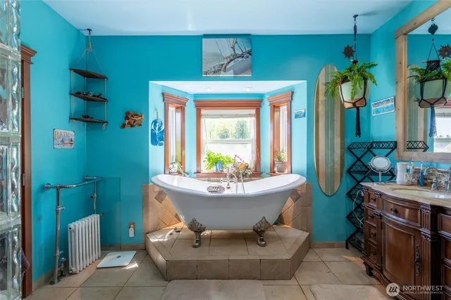 a spacious bathroom with a tub sink and mirror