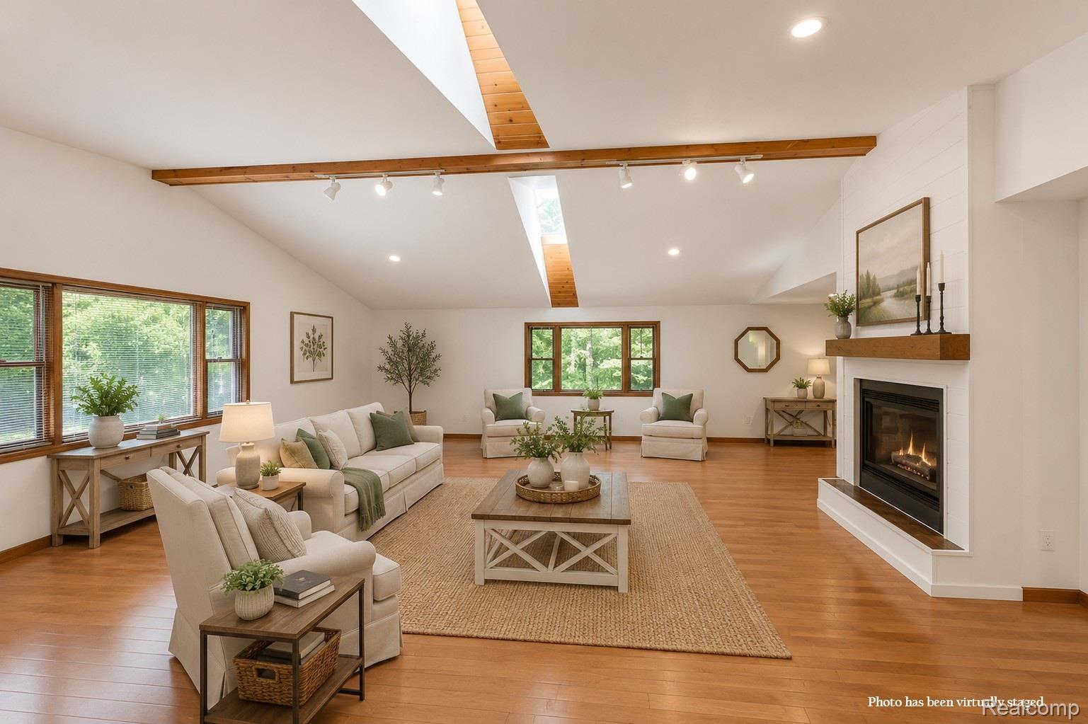 10201 Washburn Road Goodrich, MI 48438 - Photo 20 of 85 Vaulted ceiling with exposed wood beams, skylights, wood-finish flooring, and a fireplace with a wood mantel