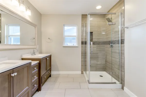 a bathroom with a shower sink vanity and mirror
