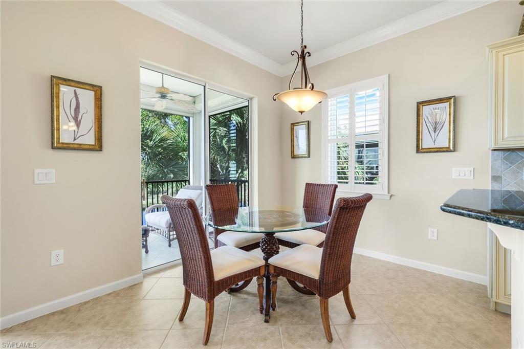 9513 Ironstone Terrace, Unit 202 Naples, FL 34120 - Photo 16 of 47 a dining room with furniture a chandelier and window