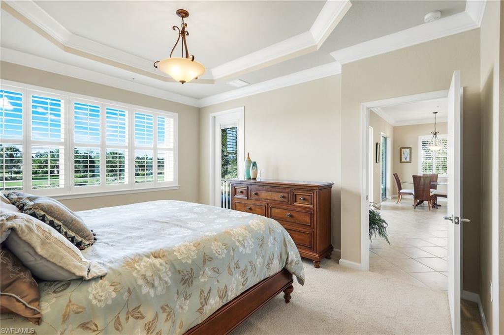 9513 Ironstone Terrace, Unit 202 Naples, FL 34120 - Photo 18 of 47 a bedroom with a bed and a chandelier