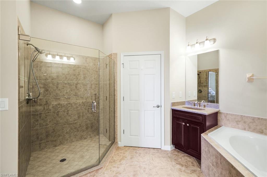 9513 Ironstone Terrace, Unit 202 Naples, FL 34120 - Photo 21 of 47 a bathroom with a bath tub sink mirror and shower