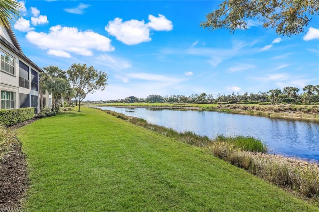 9513 Ironstone Terrace, Unit 202 Naples, FL 34120 - Photo 29 of 47 a view of a lake with houses in the back