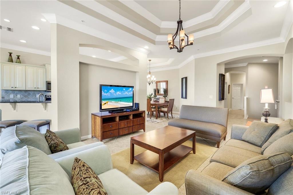 9513 Ironstone Terrace, Unit 202 Naples, FL 34120 - Photo 8 of 47 a living room with furniture and a flat screen tv