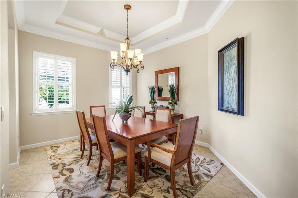 9513 Ironstone Terrace, Unit 202 Naples, FL 34120 - Photo 10 of 47 a view of a dining room with furniture and chandelier