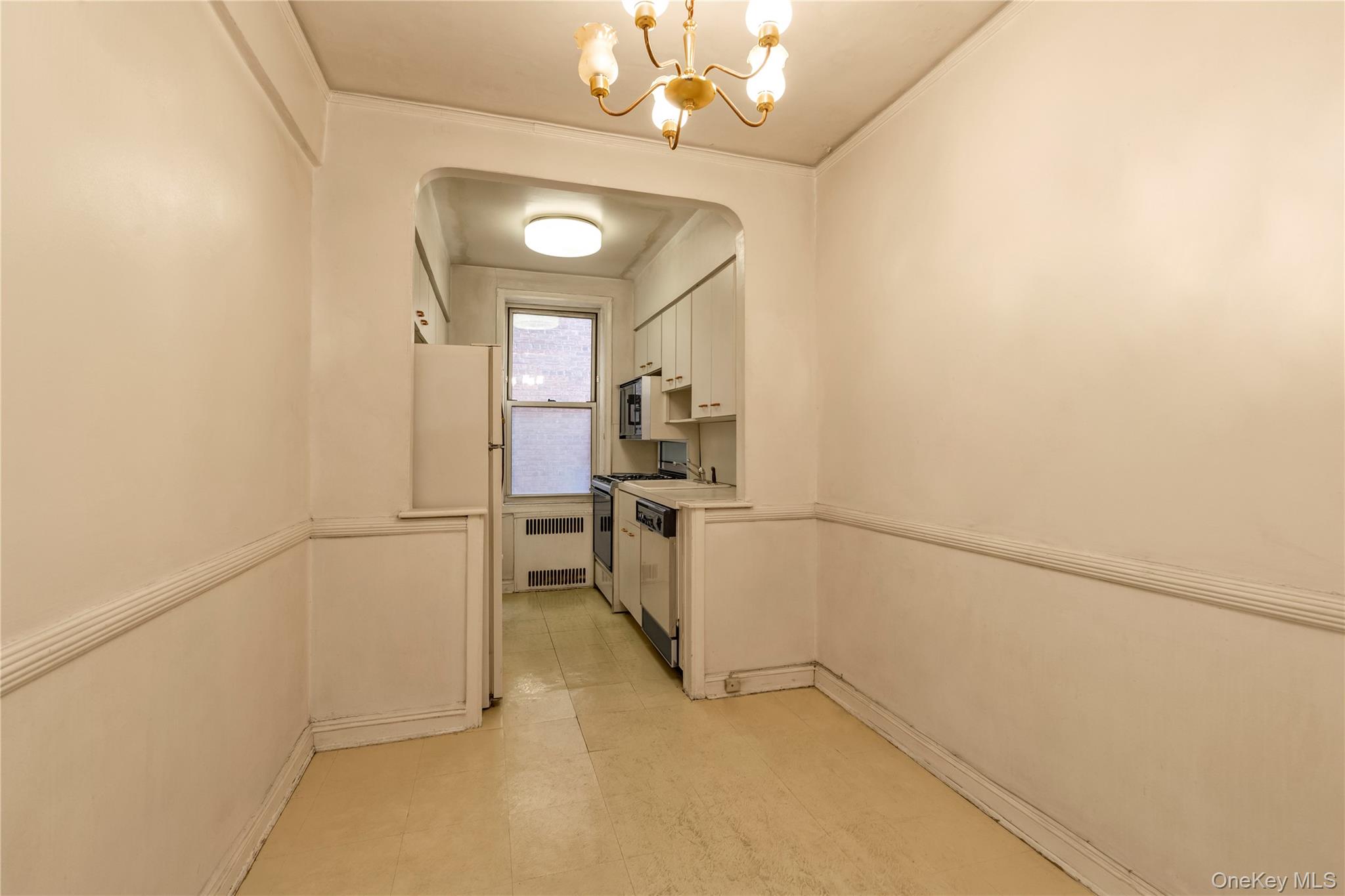 76-12 35th Avenue, Unit 1B Queens, NY 11372 - Photo 14 of 22 Corridor with a chandelier, arched walkways, and radiator