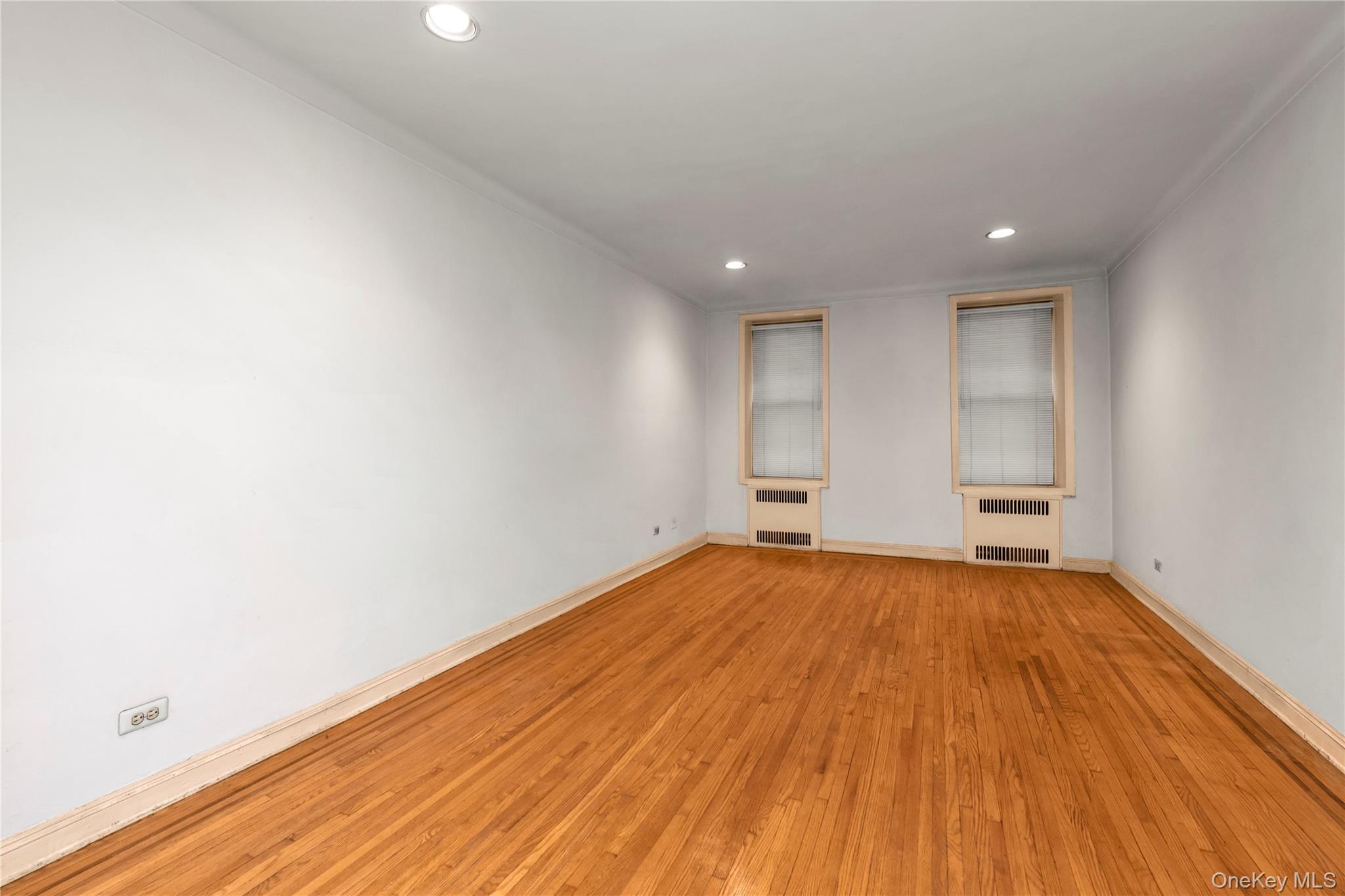 76-12 35th Avenue, Unit 1B Queens, NY 11372 - Photo 6 of 22 Spare room featuring recessed lighting, light wood finished floors, radiator, and ornamental molding