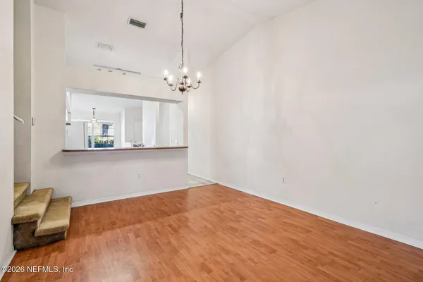 a view of a room with wooden floor and furniture