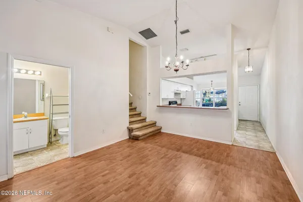 a view of an empty room and kitchen view
