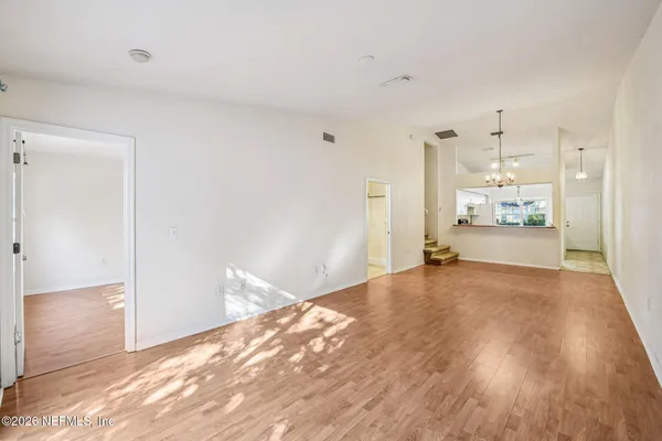 a view of a room with kitchen and wooden floor