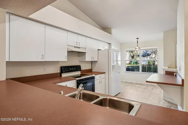 a kitchen with stainless steel appliances granite countertop a sink a stove and a refrigerator