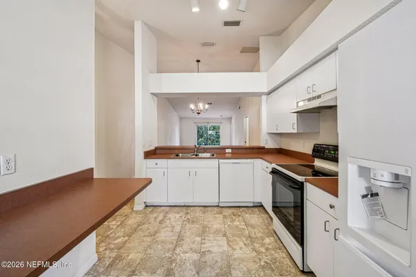 a kitchen with granite countertop a sink stove and cabinets