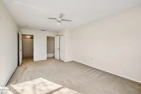 an empty room with a ceiling fan and a window