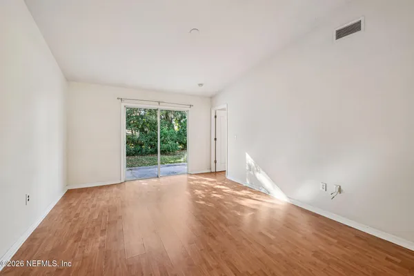 a view of a room with wooden floor and window