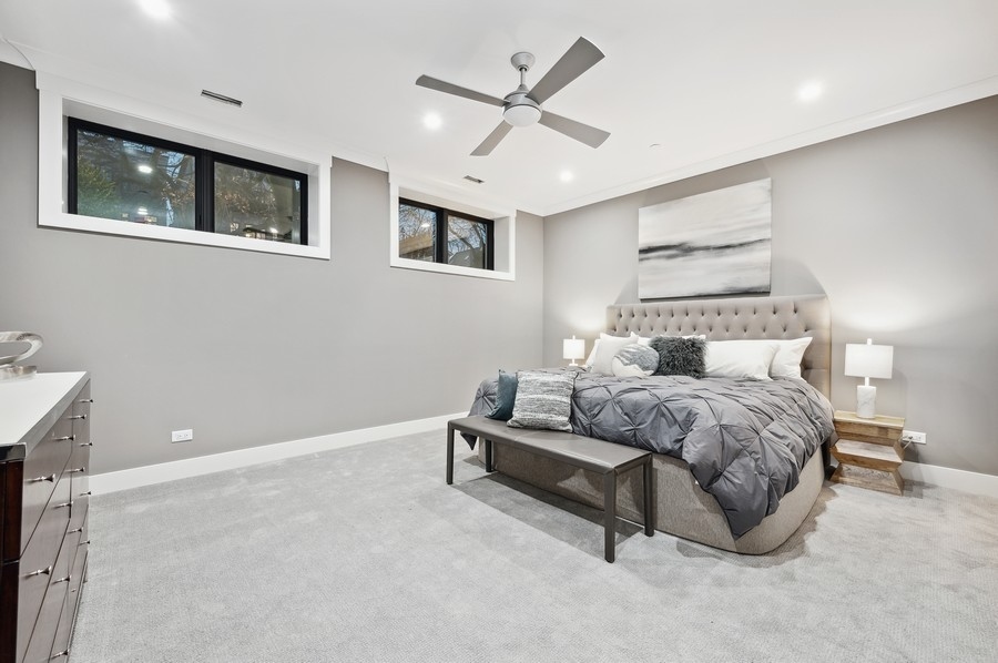 2004 West Addison Street, Unit 1E Chicago, IL 60618 - Photo 14 of 27 a spacious bedroom with a bed and a ceiling fan