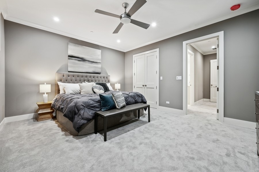 2004 West Addison Street, Unit 1E Chicago, IL 60618 - Photo 15 of 27 a spacious bedroom with a bed and a chandelier
