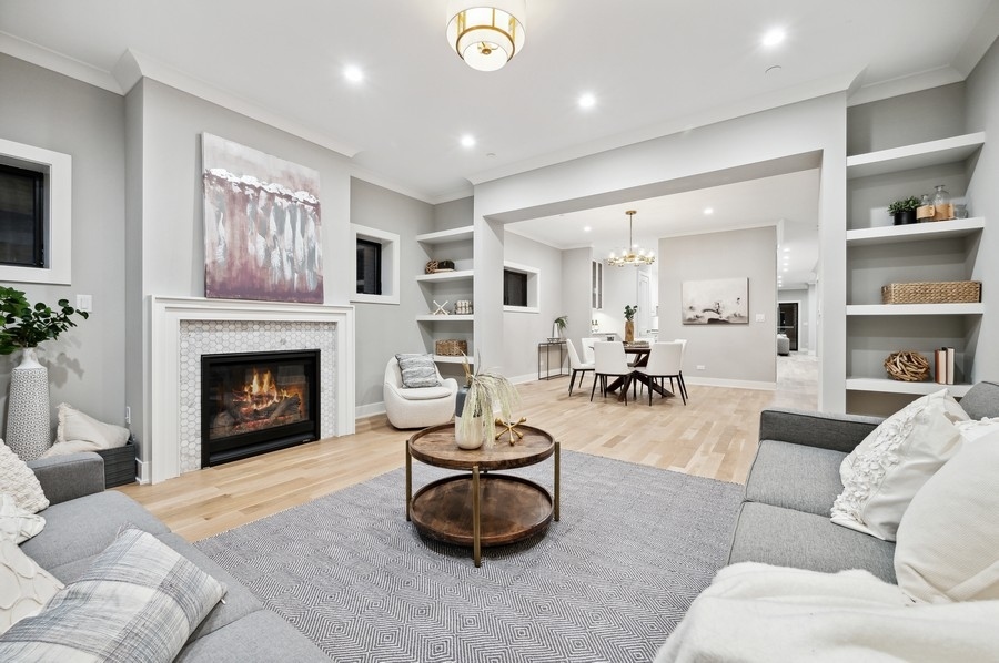 2004 West Addison Street, Unit 1E Chicago, IL 60618 - Photo 3 of 27 a living room with furniture a fireplace and a large window