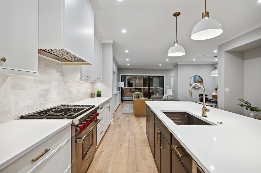 2004 West Addison Street, Unit 1E Chicago, IL 60618 - Photo 8 of 27 a kitchen with kitchen island stainless steel appliances a sink a counter top space stove and cabinets