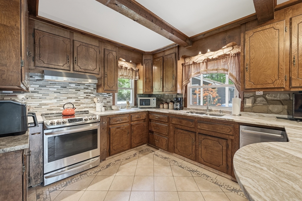 43 Flint Road Tyngsborough, MA 01879 - Photo 7 of 40 a kitchen with a stove sink and cabinets