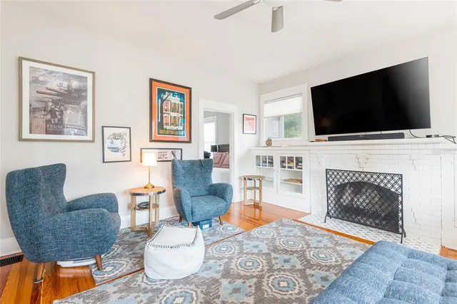 a living room with furniture a flat screen tv and a fireplace
