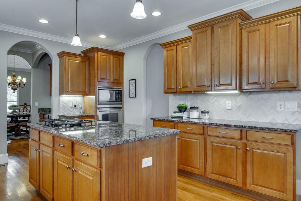 1219 White Rock Road Spring Hill, TN 37174 - Photo 11 of 30 a kitchen with stainless steel appliances granite countertop a sink a stove cabinets and living room view