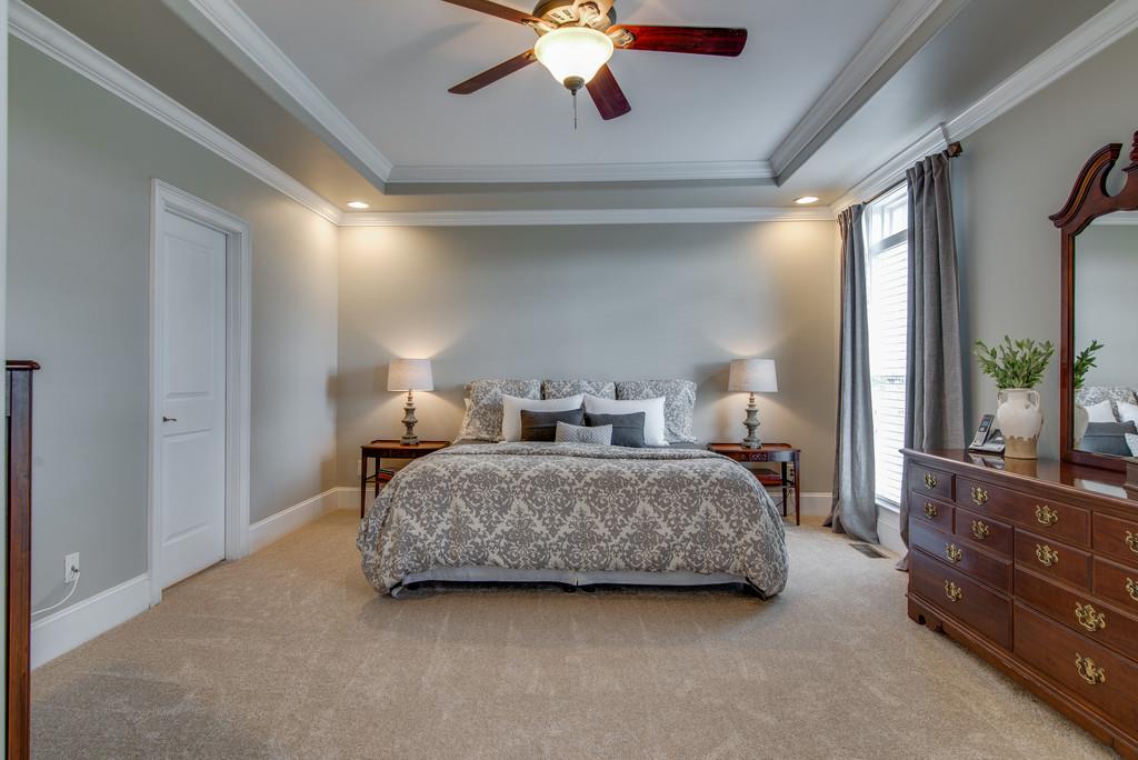 1219 White Rock Road Spring Hill, TN 37174 - Photo 15 of 30 a spacious bedroom with a bed and a chandelier