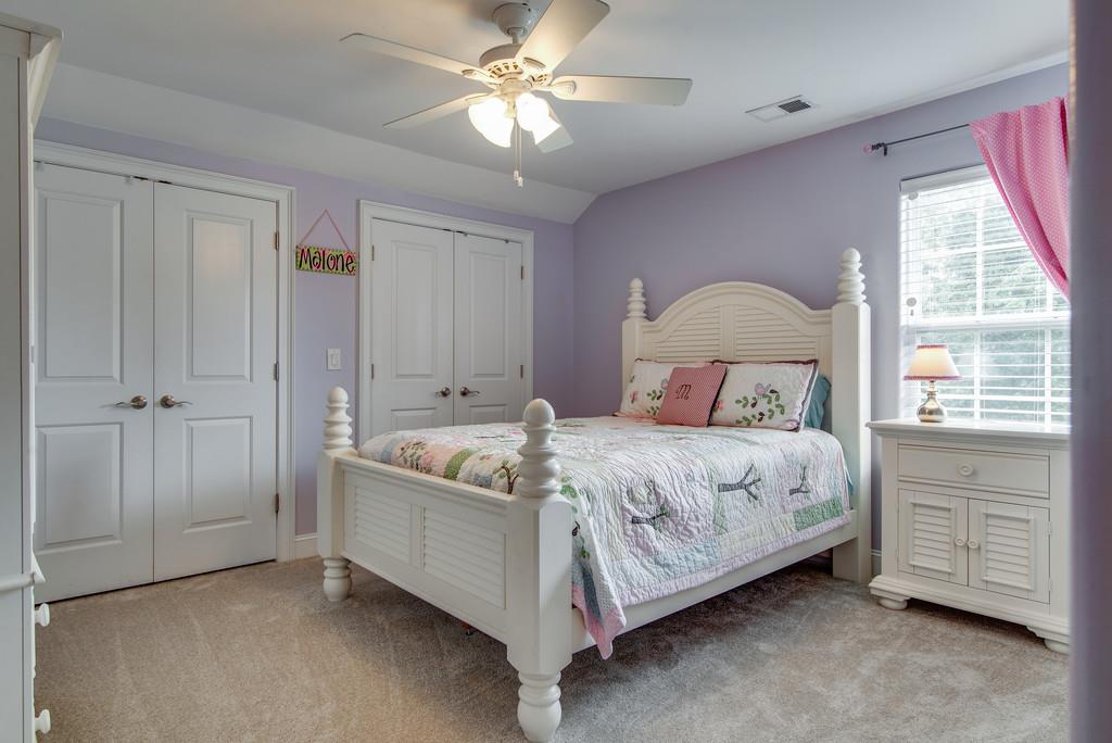 1219 White Rock Road Spring Hill, TN 37174 - Photo 25 of 30 a bedroom with a bed and a chandelier