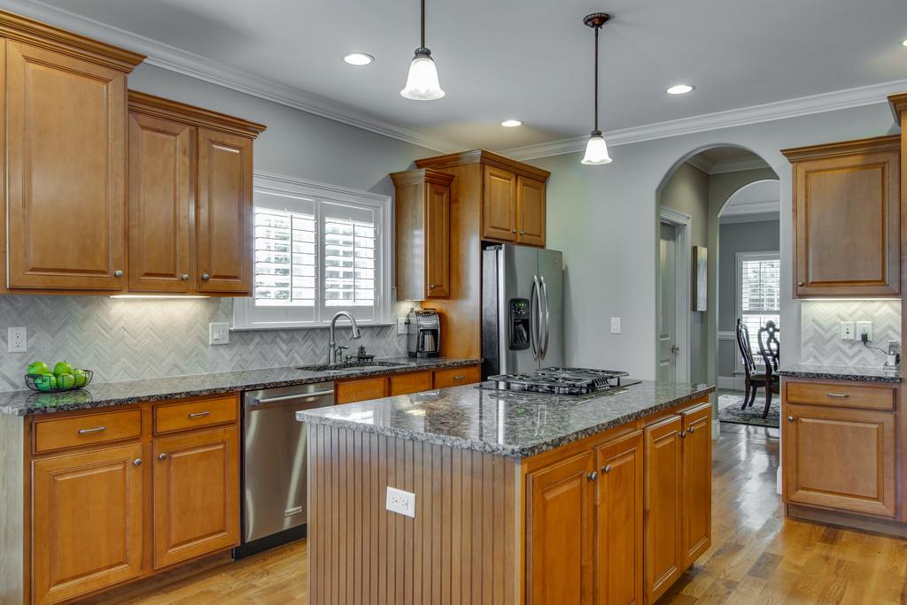 1219 White Rock Road Spring Hill, TN 37174 - Photo 9 of 30 a kitchen with stainless steel appliances granite countertop a sink a stove cabinets and living room view
