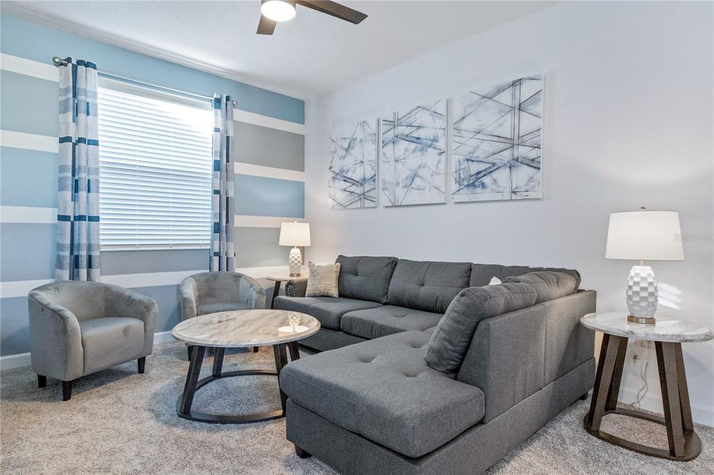 3032 Protagonist Street Kissimmee, FL 34746 - Photo 11 of 34 a living room with furniture and a lamp