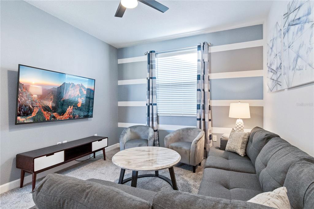 3032 Protagonist Street Kissimmee, FL 34746 - Photo 12 of 34 a living room with furniture and a flat screen tv