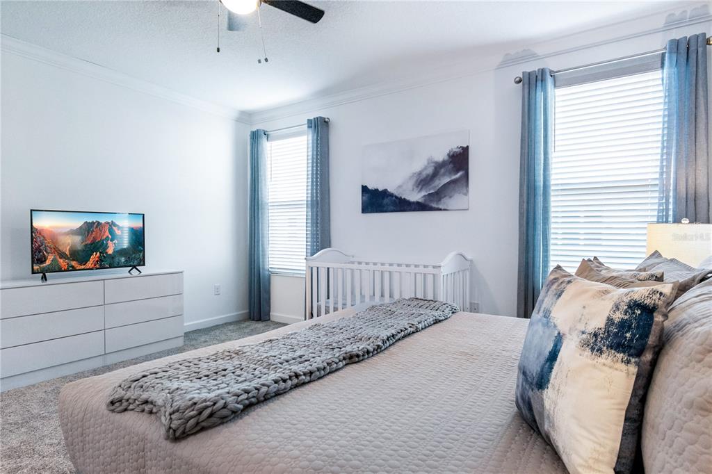 3032 Protagonist Street Kissimmee, FL 34746 - Photo 14 of 34 a bedroom with a bed and a painting on the wall