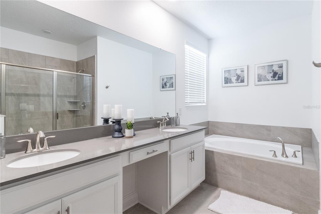 3032 Protagonist Street Kissimmee, FL 34746 - Photo 15 of 34 a bathroom with a granite countertop bathtub sink double and mirror