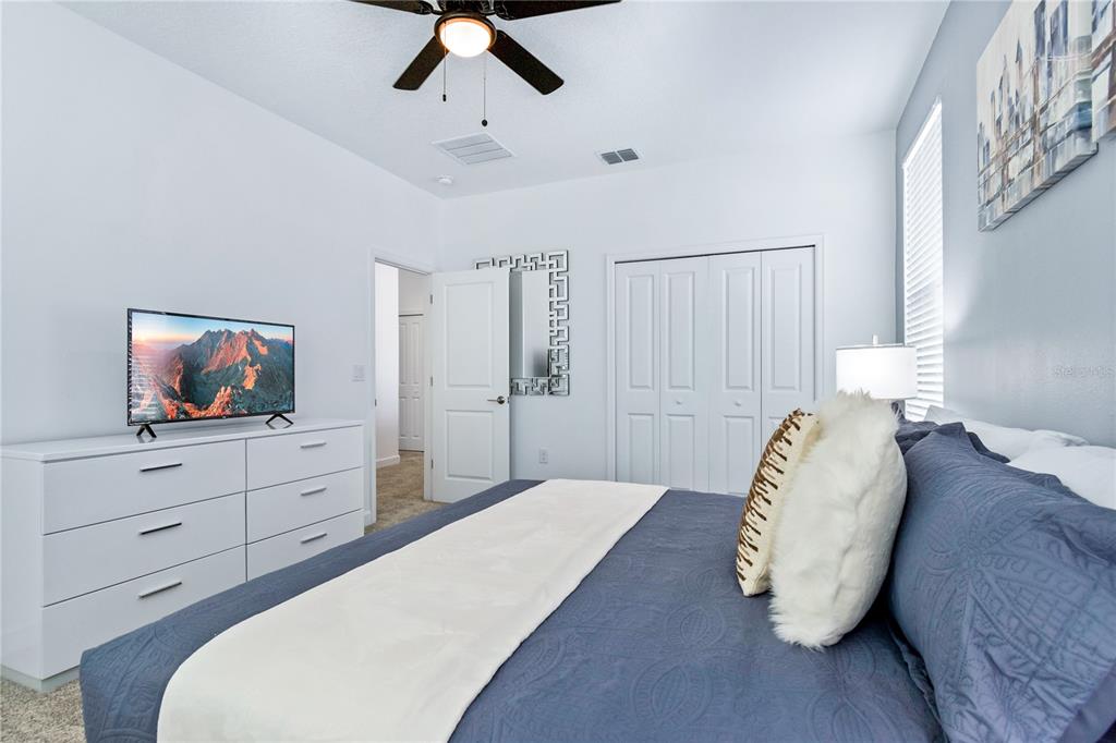 3032 Protagonist Street Kissimmee, FL 34746 - Photo 20 of 34 a bedroom with a bed and a flat screen tv