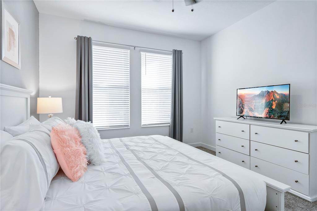 3032 Protagonist Street Kissimmee, FL 34746 - Photo 26 of 34 a bedroom with a bed and a television