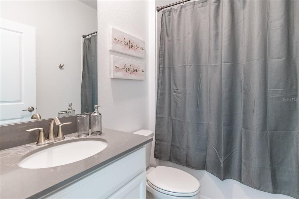 3032 Protagonist Street Kissimmee, FL 34746 - Photo 27 of 34 a bathroom with a granite countertop sink toilet and shower